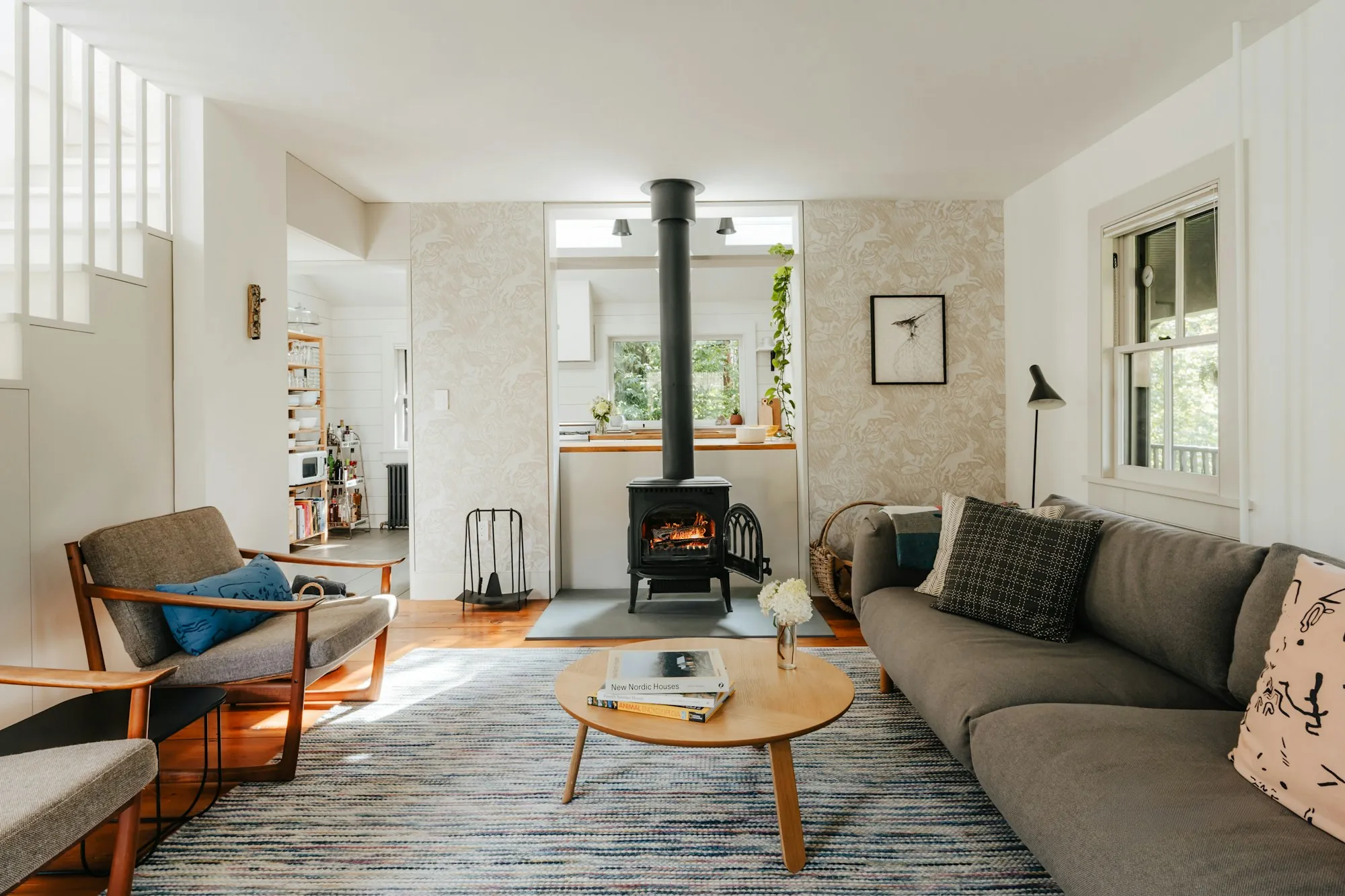 Living room with a wood stove and mid-century chairs